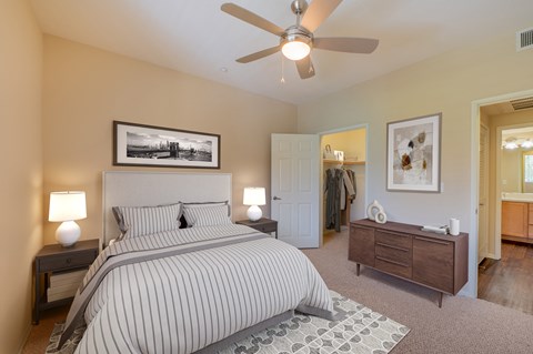 a bedroom with a large bed and a ceiling fan  at Ventana Senior Apartments, Northridge, CA
